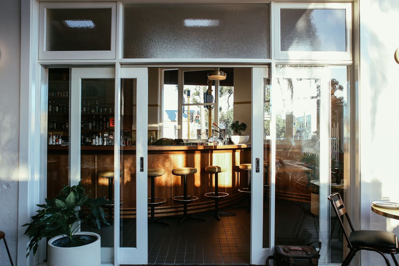 Glass entrance doors on a restaurant: high cycle counts demand quality patch fittings and closers.
