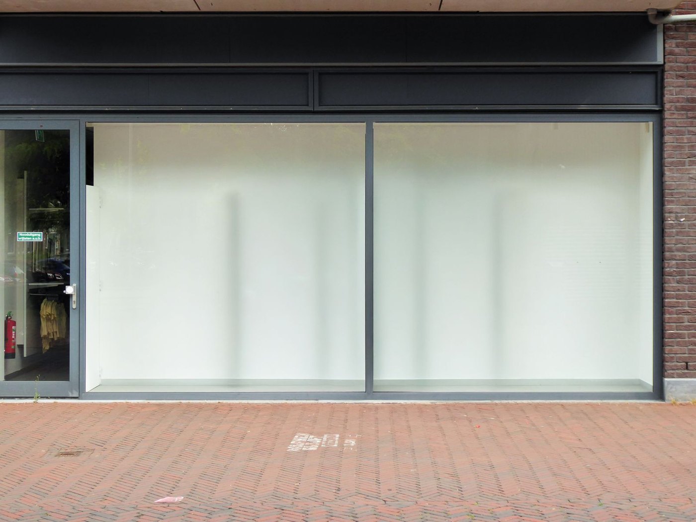 Large-format storefront glazing: ground-floor framing sized for daylight, access and security.